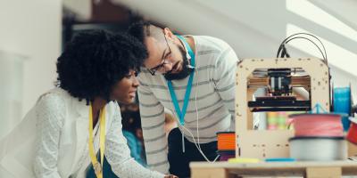 Woman and man with 3D printer