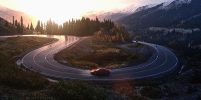Red sports car driving on winding road